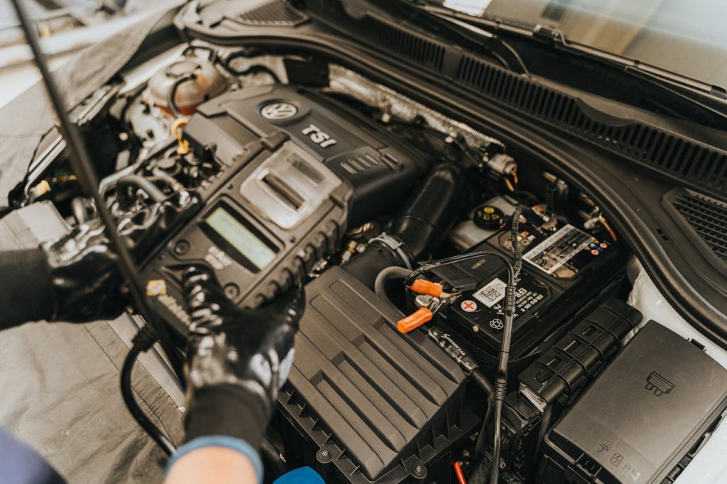 Close-up view of a mechanic diagnosing a Volkswagen engine with specialized equipment.