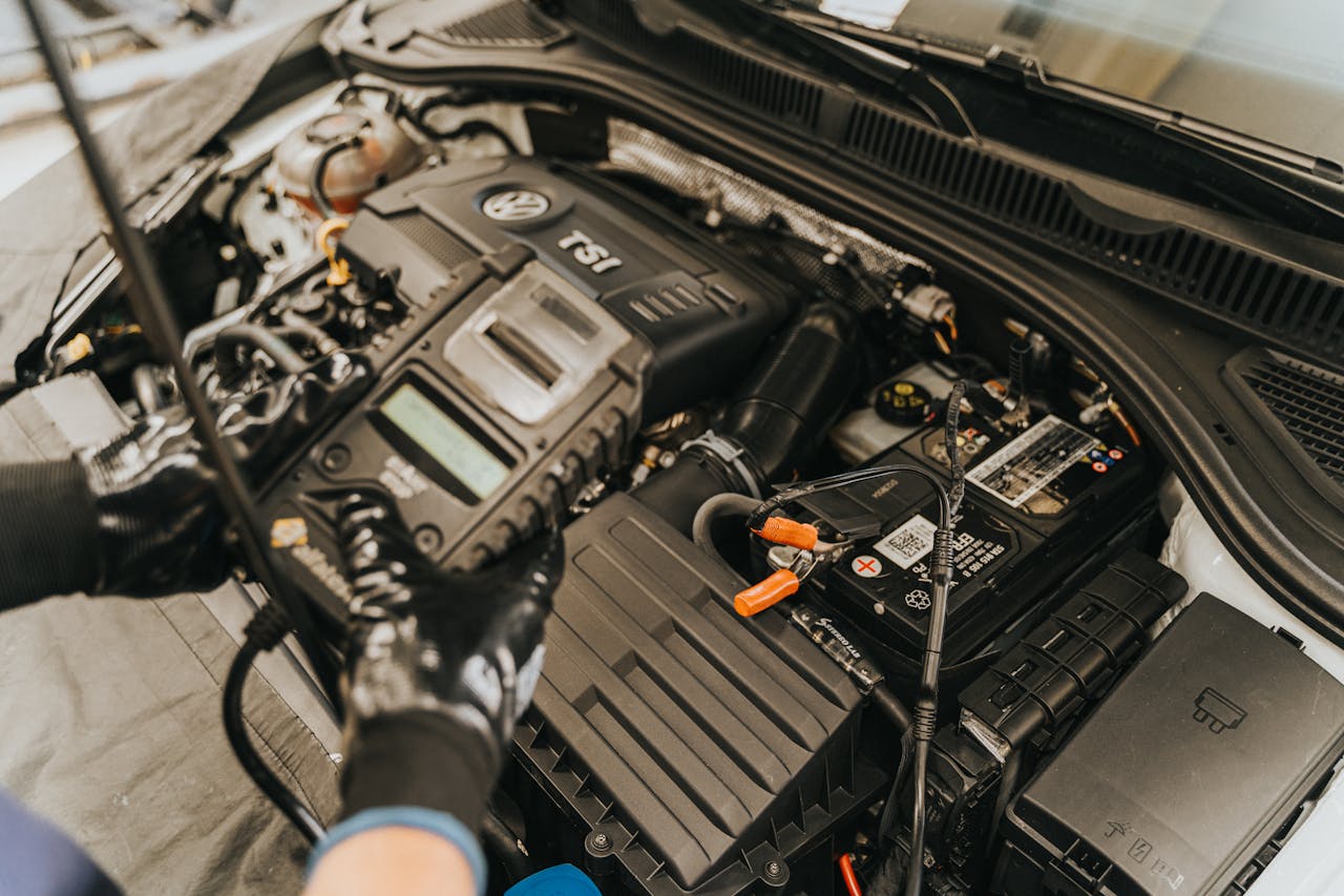 Close-up view of a mechanic diagnosing a Volkswagen engine with specialized equipment.